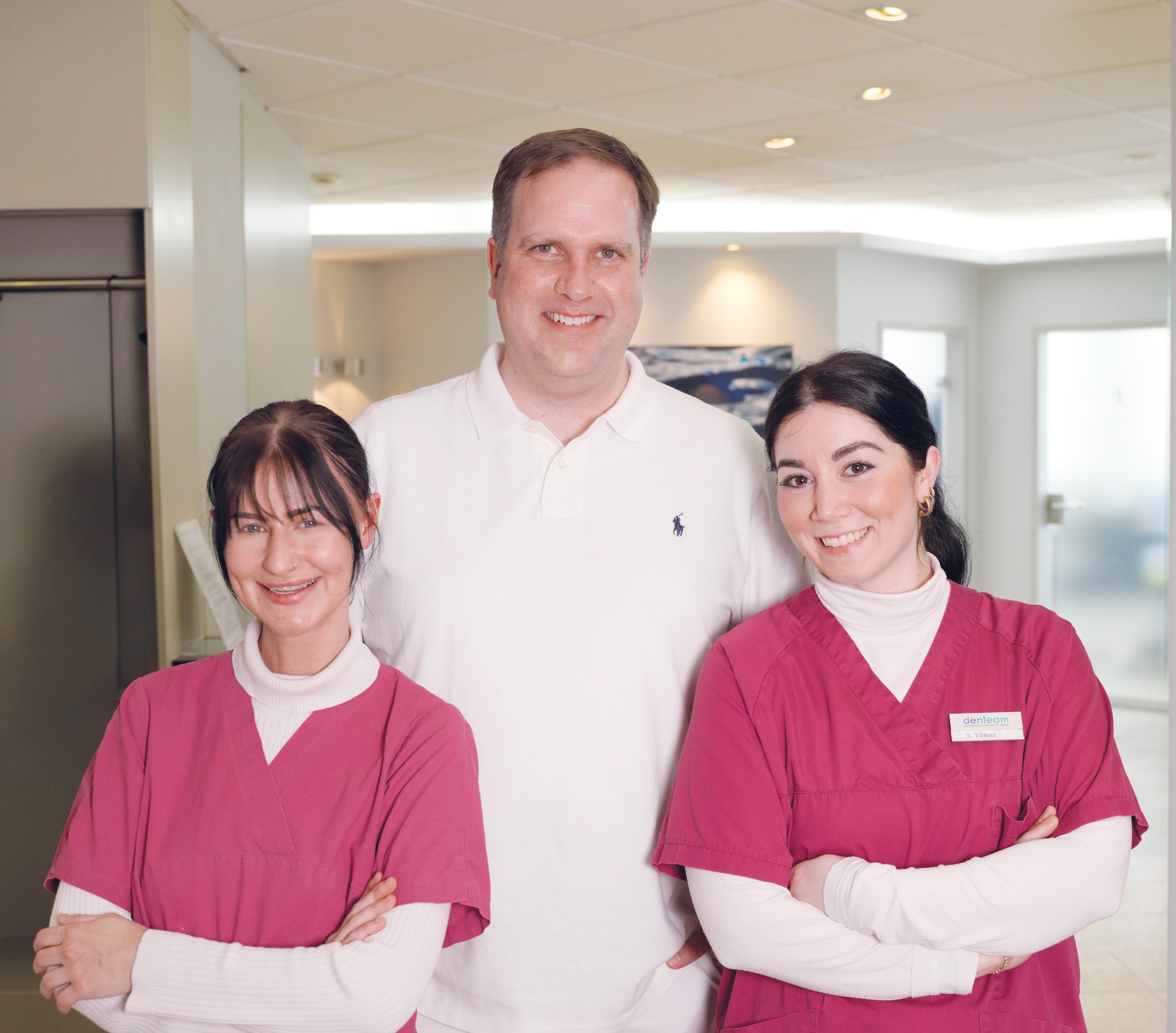 Dr. Breuer mit Praxisteam vorm Empfang stehend